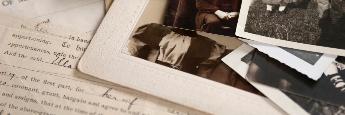 a stack of old black and white photographs on top of a letter written in cursive