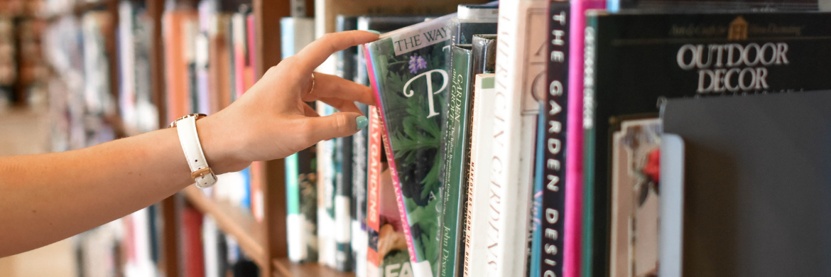 Person selecting a book from one of the shelves in the library