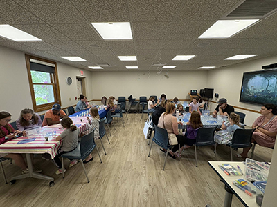 Large room with tables in a U-shape and people surrounding the tables