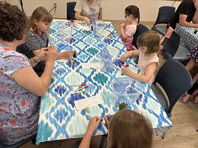 One adult and five children sitting around a table