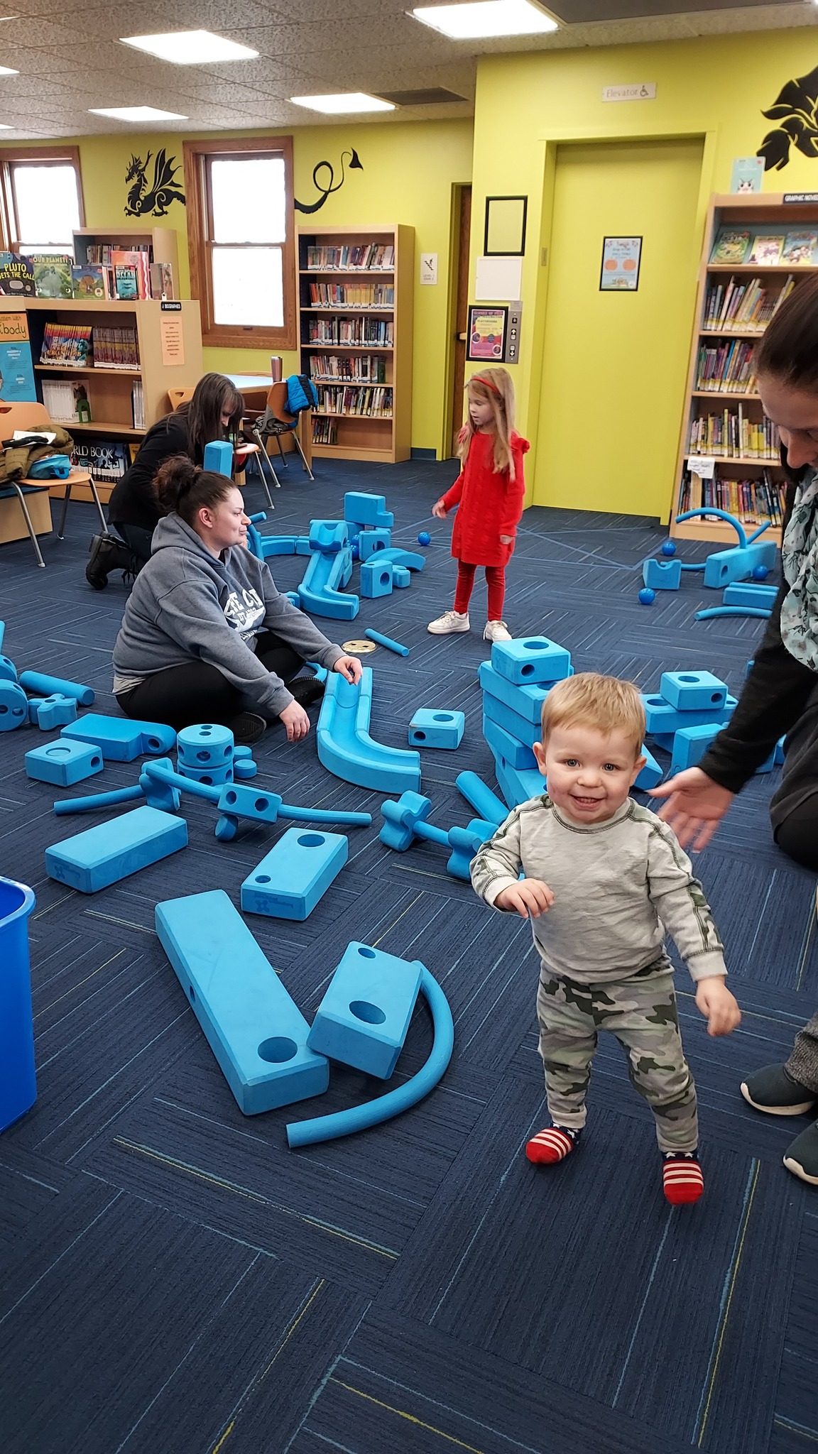 Imagination Playground - small child smiling for camera in front of playground
