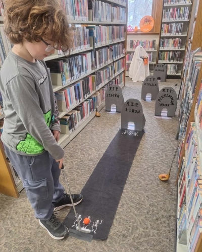 boy playing headstones hole mini-golf course