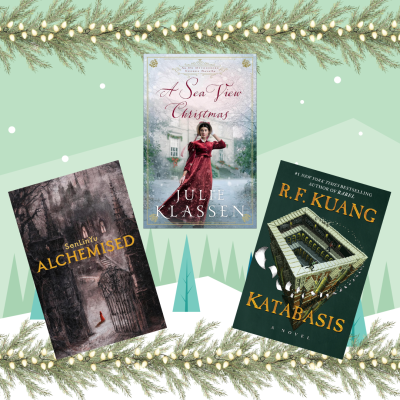Three book covers are displayed against a winter-themed backdrop with pine branches and lights. The center book, "A Sea View Christmas," depicts a woman in a red dress in a snowy scene. To the left is "Alchemised," featuring a dark, mysterious forest and gate. To the right is "Katabasis," showing an architectural structure. The mood is festive and intriguing.