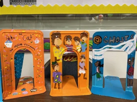 A photo of several bookends hand painted to resemble popular book covers.