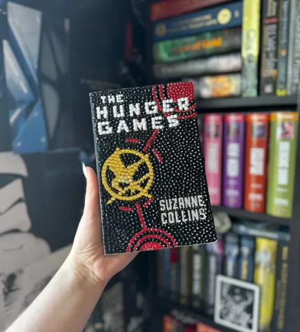 A bedazzled copy of The Hunger Games by Suzanne Collins.