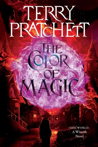 Cover of "The Color of Magic" by Terry Pratchett features a figure in a wizard hat facing a purple magical swirl, against a backdrop of fiery red-tinted rooftops. Fantasy theme.