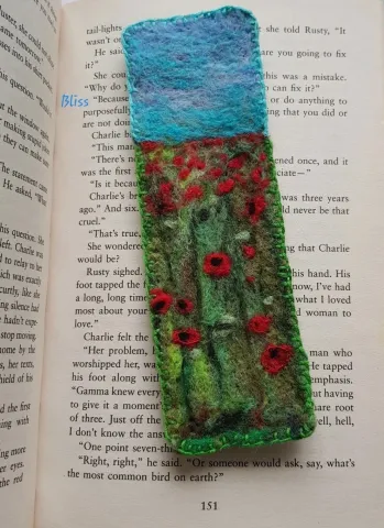 a felted bookmark laying on an open page of a book