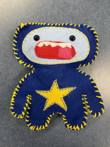 A handmade blue monster made of felt.