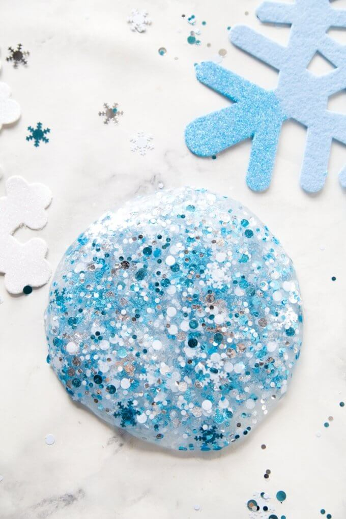 A pile of clear slime decorated with light and dark blue sparkles.
