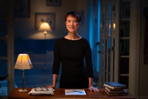 Photo of Tess Gerritsen standing at a desk