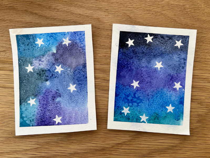 Two handmade watercolor painted cards in various shades of blue and purple.