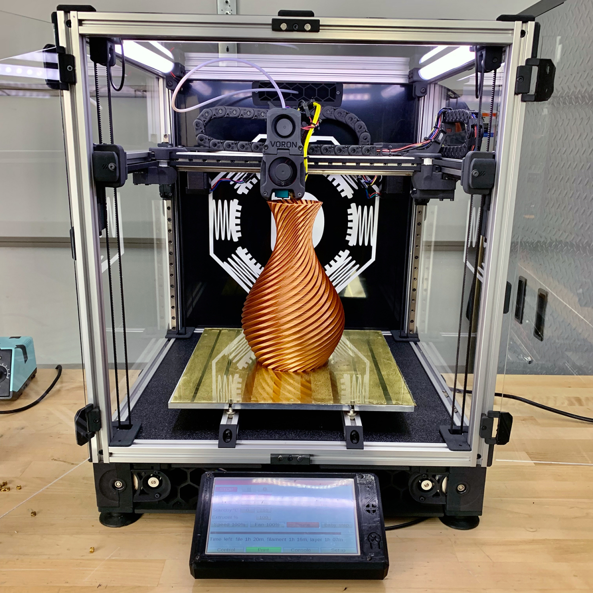 A 3D printer creating a small gold vase.