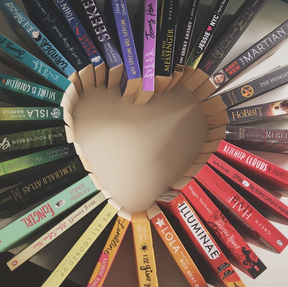 Multi colored books placed spine up in the shape of a heart